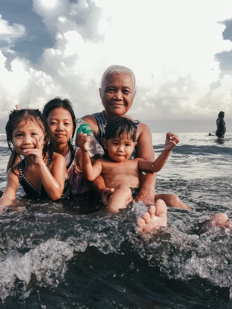 three children and man at the beach