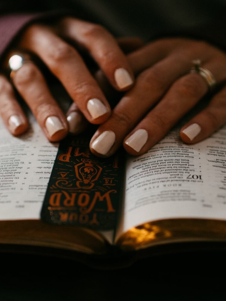 person wearing silver ring on ring finger on book page